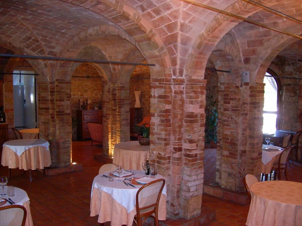 un comedor con mesas y sillas en un edificio en Case Cordovani, en Magliano in Toscana