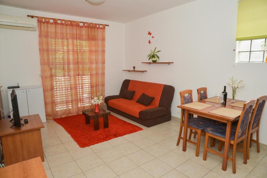 sala de estar con sofá, mesa y silla en Latmo Apartment Zadar, en Zadar