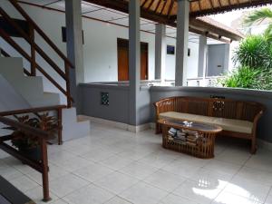 un patio con banco, mesa y escaleras en Celagi Inn, en Padangbai