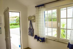 a room with a window with a view of a yard at Casal Do Góis Guest House in Atouguia da Baleia