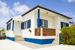 a white and blue house with blue shutters at Casal Do Góis Guest House in Atouguia da Baleia