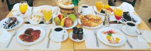 a table topped with plates of breakfast foods and drinks at Theoxenia Palace in Athens