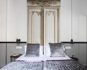 um quarto com uma cama com duas almofadas em Hotel Malte - Astotel em Paris