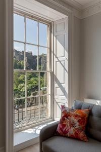 sala de estar con sofá y ventana grande en Destiny Scotland - Chisholm Hunter Suites, en Edimburgo