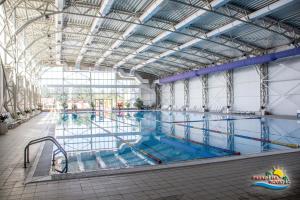 une grande piscine intérieure d'eau bleue dans l'établissement Hotel Alinalex - Paradisul Acvatic, à Braşov