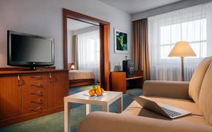 a hotel room with a couch and a television at Clarion Congress Hotel Ostrava in Ostrava