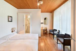 Cette chambre comprend un lit, un bureau et une fenêtre. dans l'établissement Hotel National Bern, à Berne