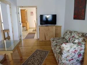 a living room with a couch and a flat screen tv at Gartler's Appartements in Kalsdorf bei Graz