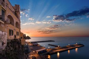 een uitzicht op de oceaan en een pier bij zonsondergang bij Vista d'Amalfi in Amalfi