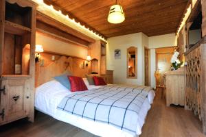 1 dormitorio con 1 cama grande y techo de madera en Hotel L'Equipe, en Morzine