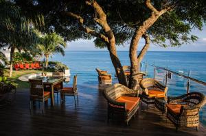 a patio with a table and chairs and the ocean at Hotel Vistalmar in Manta