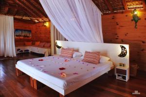 een slaapkamer met een wit bed met bloemen erop bij Anjiamarango Beach Resort in Nosy Be