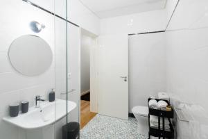 uma casa de banho branca com um lavatório e um WC em Oporto Serviced Apartments - Alvares Cabral no Porto