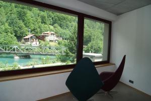 Habitación con silla y ventana con vistas a un puente. en Interlaken Youth Hostel, en Interlaken