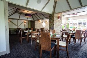 comedor con mesas y sillas de madera en The Legacy Rose & Crown Hotel, en Salisbury