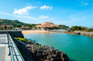 - une vue sur une plage avec un bâtiment en arrière-plan dans l'établissement Playa De Arnadal Isla, à Isla