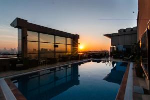 un edificio con piscina con il tramonto sullo sfondo di Best Western Plus Pearl Creek a Dubai