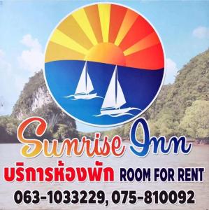 um sinal para uma pousada de verão com um veleiro na água em Sunrise Inn em Cidade de Krabi