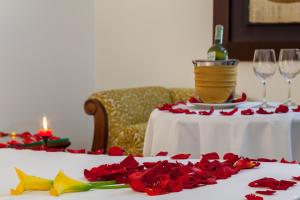 un tavolo con rose rosse e una bottiglia di vino di Hotel Embassy Park a Bogotá