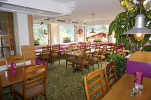 une salle à manger avec des tables et des chaises en bois dans l'établissement Hotel Alpenblick, à Grindelwald