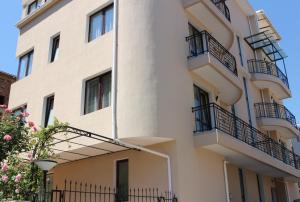 - un bâtiment blanc avec des balcons sur le côté dans l'établissement Flowers Apartments, à Nessebar