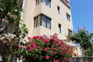 un bâtiment avec des fleurs roses devant lui dans l'établissement Flowers Apartments, à Nessebar