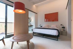 a bedroom with a bed and a table and a chair at Sodium Boutique Hotel in Ciutadella