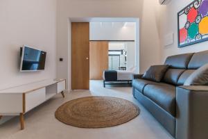 a living room with a couch and a tv at Sodium Boutique Hotel in Ciutadella