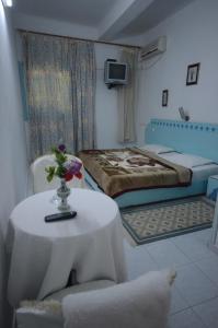 Cette chambre comprend un lit et une table avec un vase de fleurs. dans l'établissement Houria House Sable D'or, à Mahdia