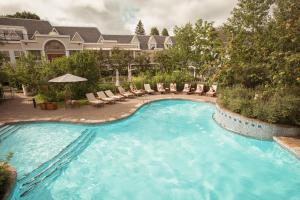 une piscine avec des chaises longues et un hôtel dans l'établissement Hôtel Le Bonne Entente, à Québec