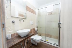 uma casa de banho com um WC e uma cabina de duche em vidro. em Trinity Luxury Rooms em Roma