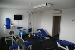 een fitnessruimte met blauwe stoelen en apparatuur in een kamer bij Hotel Metropol in Spišská Nová Ves