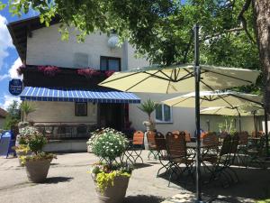 a patio with tables and chairs and an umbrella at Gasthof Ogertschnig in Klagenfurt