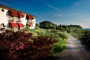 een gebouw met rode luifels aan de kant van een weg bij Hotel Mon Repos in Sirmione