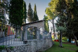 een stenen muur met een poort in een park bij Hotel Mon Repos in Sirmione