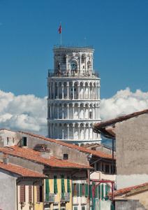 uma torre com uma bandeira no topo de um edifício em B&B 7 Rooms em Pisa