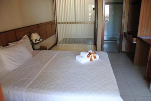 een wit bed met een teddybeer erop bij Pousada Cambucá de Cabo Frio in Cabo Frio