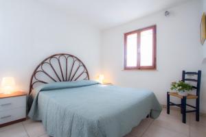 um quarto com uma cama com um cobertor azul e uma janela em Al Pozzo Residence em Capoliveri