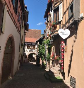 um beco com um sinal de coração no lado de um edifício em Les Authentics - La Maison d'Amélie em Riquewihr