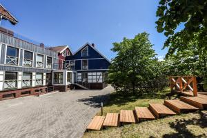 een groot blauw gebouw met houten banken ervoor bij Nida Vėtrungių 3 , apartamentai in Nida