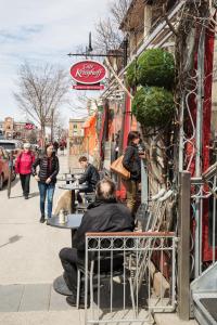 Ein Mann, der vor einem Restaurant an einem Tisch sitzt. in der Unterkunft Petit Hôtel - Café Krieghoff in Québec