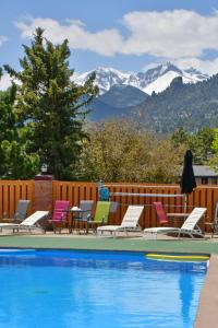 una piscina con sedie e montagne sullo sfondo di Murphy's Resort a Estes Park