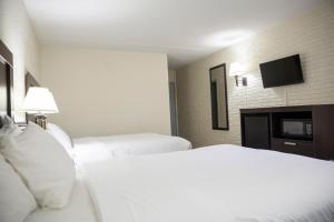 a hotel room with two beds and a flat screen tv at Inns of Virginia Arlington in Arlington