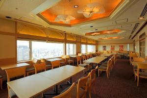 een eetkamer met tafels, stoelen en ramen bij Shin Osaka Washington Hotel Plaza in Osaka