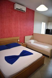 a bedroom with a bed with a blue ribbon on it at Hotel Shkodra L in Shkodër