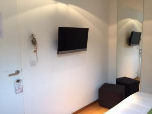 - une chambre avec une télévision murale à écran plat dans l'établissement Hotel Le Clos des Récollets, à Durbuy