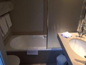 La salle de bains est pourvue d'un lavabo et d'une baignoire. dans l'établissement Hotel Le Clos des Récollets, à Durbuy