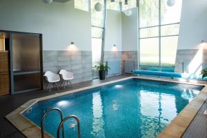 una piscina en una habitación de hotel con sillas alrededor en Hotel Sigulda, en Sigulda