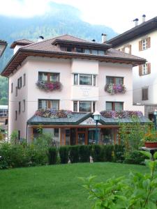 um grande edifício branco com caixas de flores em Appartements Tlusel em Ortisei