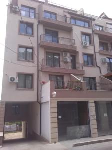 - un grand bâtiment blanc avec des fenêtres et des balcons dans l'établissement Apartments Hristovi, à Sandanski